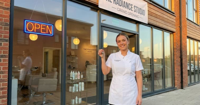 Beauty therapist holding keys outside a newly opened salon