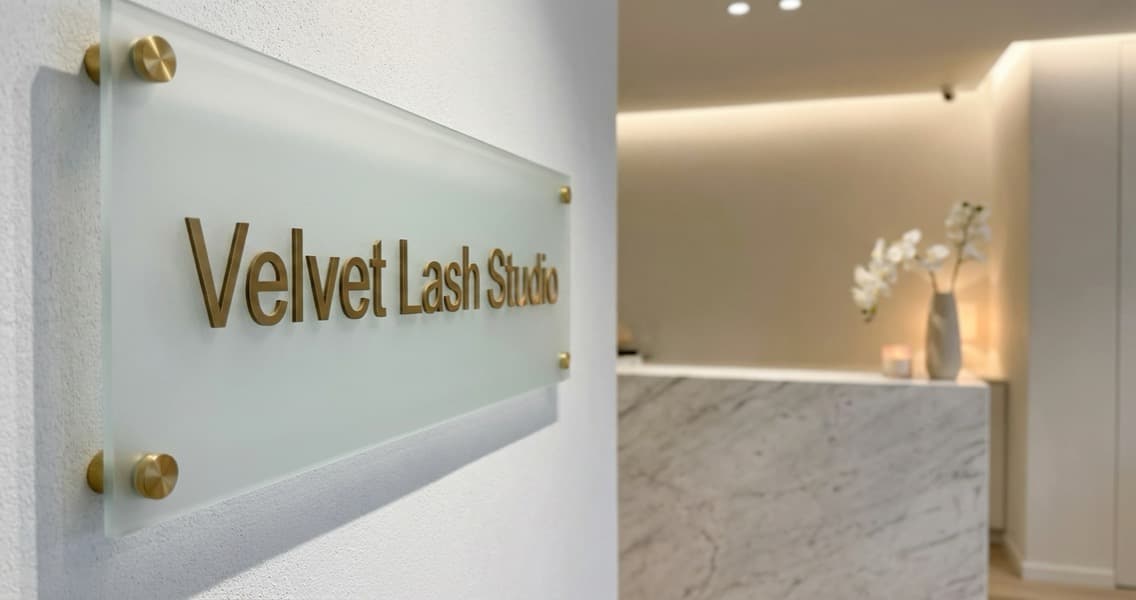Elegant lash studio signage displayed on a frosted glass door in a minimalist beauty salon