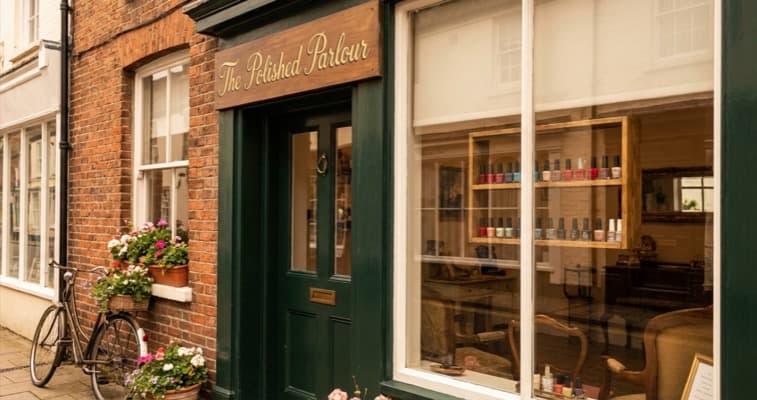 Nail salon storefront with elegant handwritten sign and window display